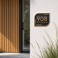 Antique brass address plaque with 908 and Northline Avenue on dark backing, modern asymmetric