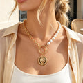 Gold-tone chain and faux pearl necklace with round coin pendant and ring link