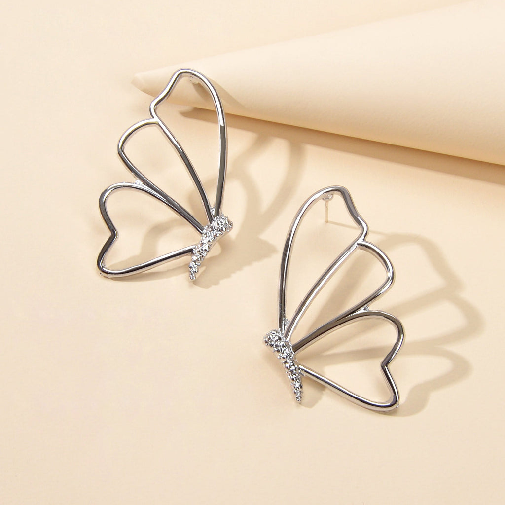 Silver hollow butterfly stud earrings with rhinestone cluster, pierced design