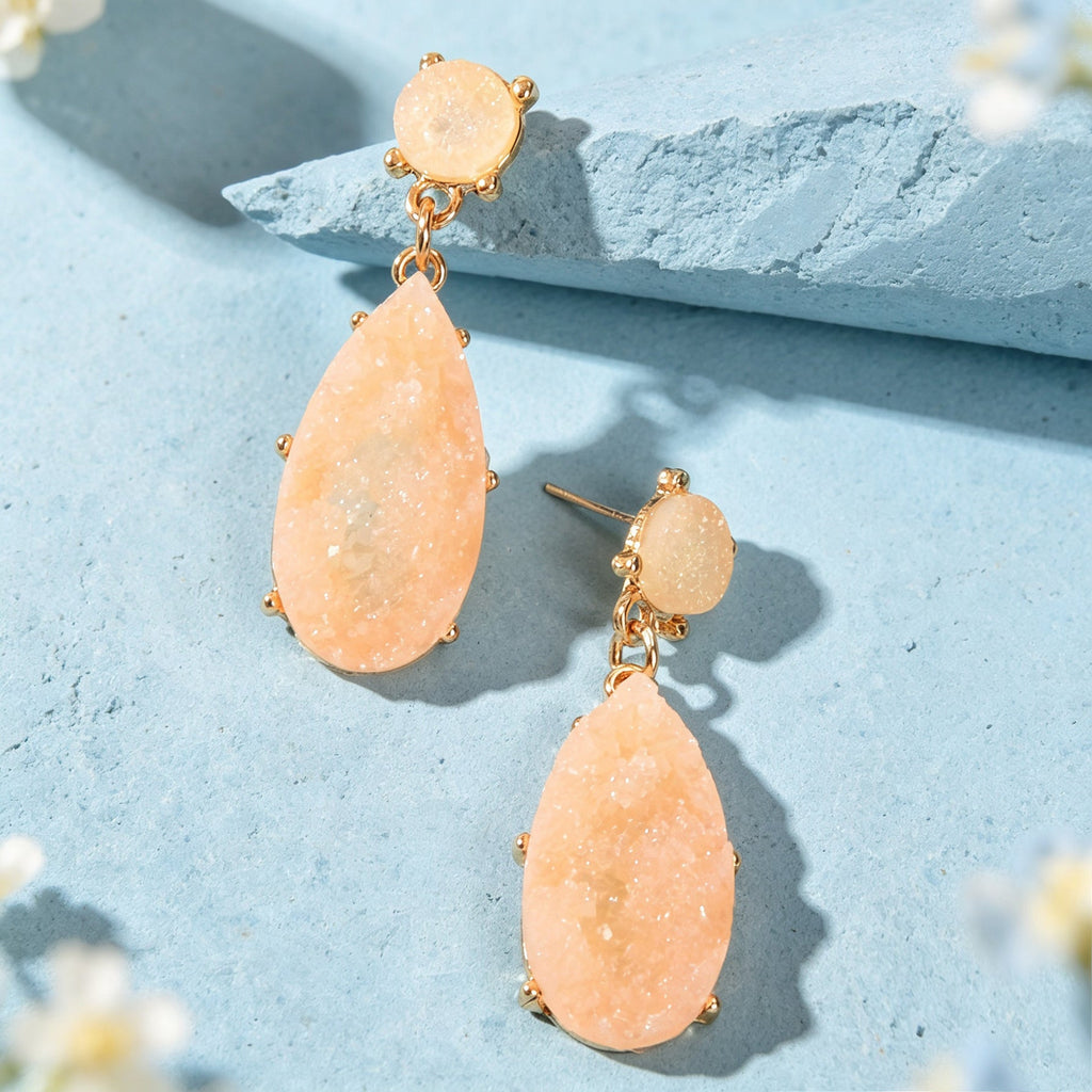Peach teardrop dangle earrings with gold-tone round tops and linked faux gemstones.