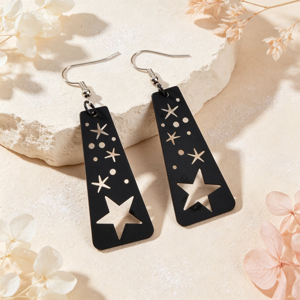 Black geometric dangle earrings with constellation stars and moon cutouts, gold-tone hooks