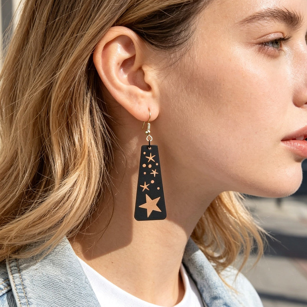 Starry sky black dangle earrings with moon and star cutouts, on gold-tone hooks