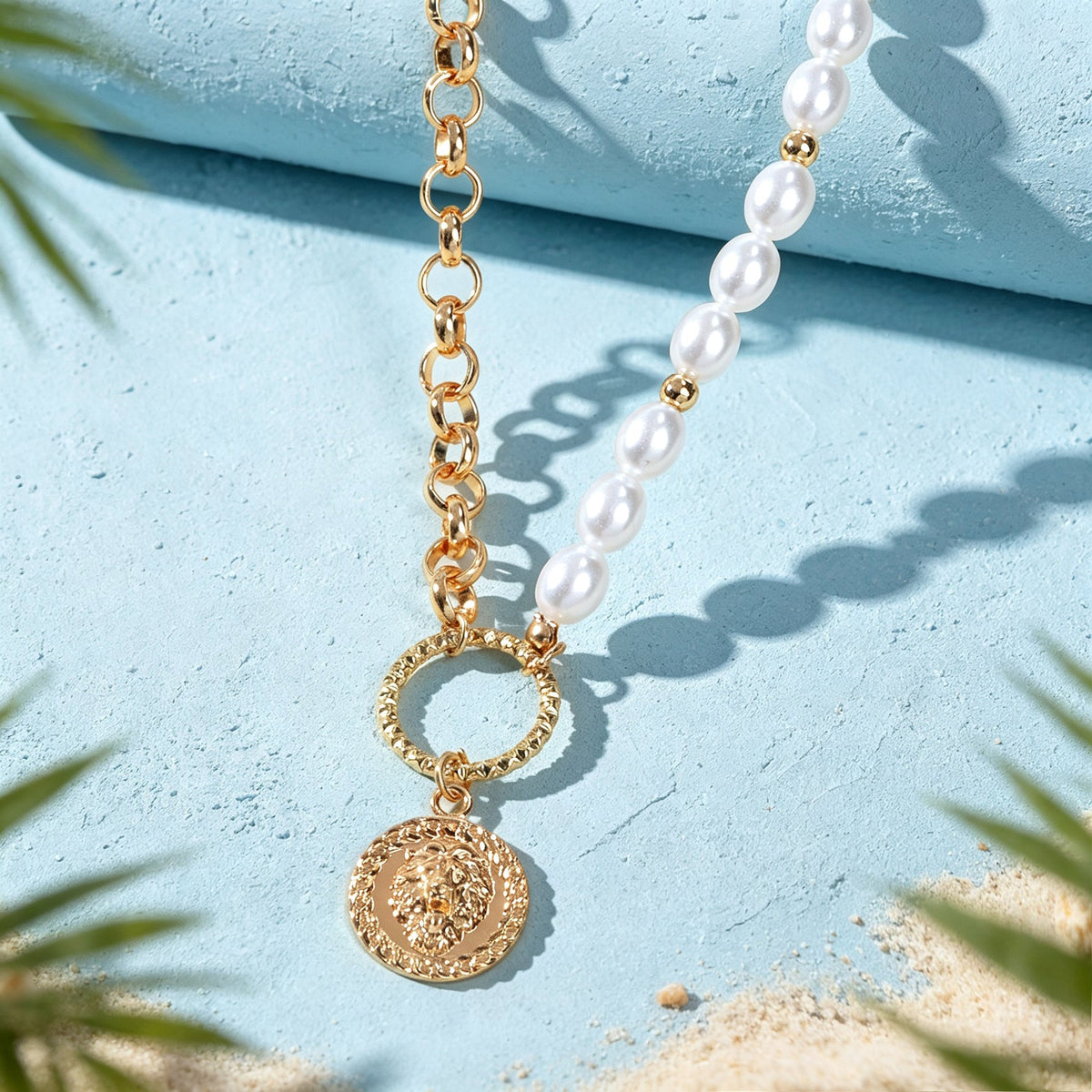 Gold-tone necklace close-up with faux pearl strand and round coin pendant