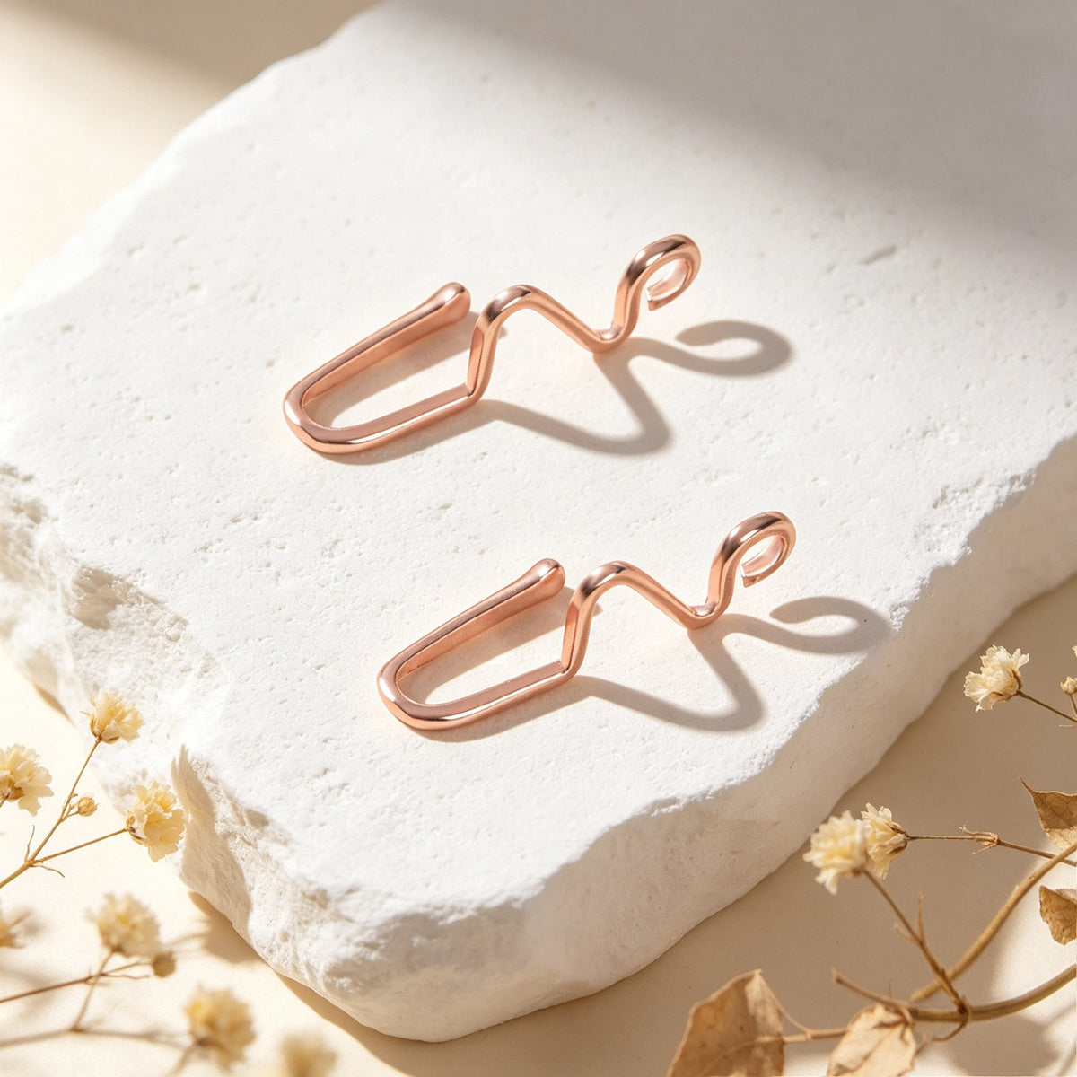Rose gold wave ear cuffs, set of two, close view on white stone