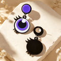 Purple cartoon big-eye acrylic dangle earrings with black and white eye details