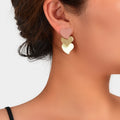 Multicolor heart dangle earrings on ear, layered pink, cream, and gold hearts