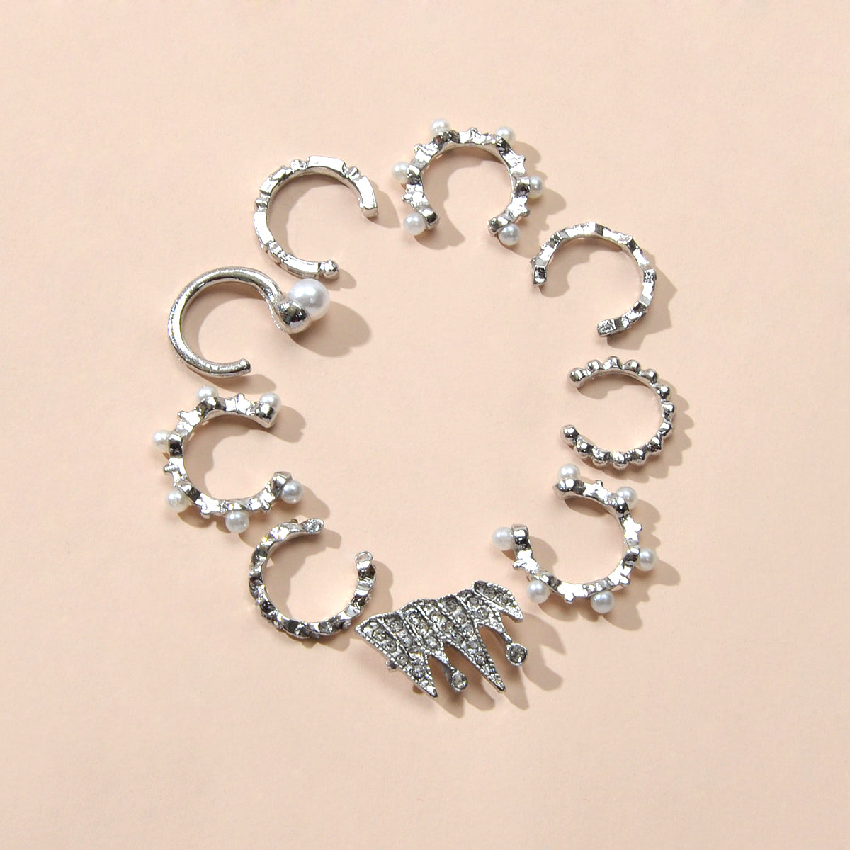 Silver ear cuff set with rhinestones, pearl-like beads, and one spiky charm