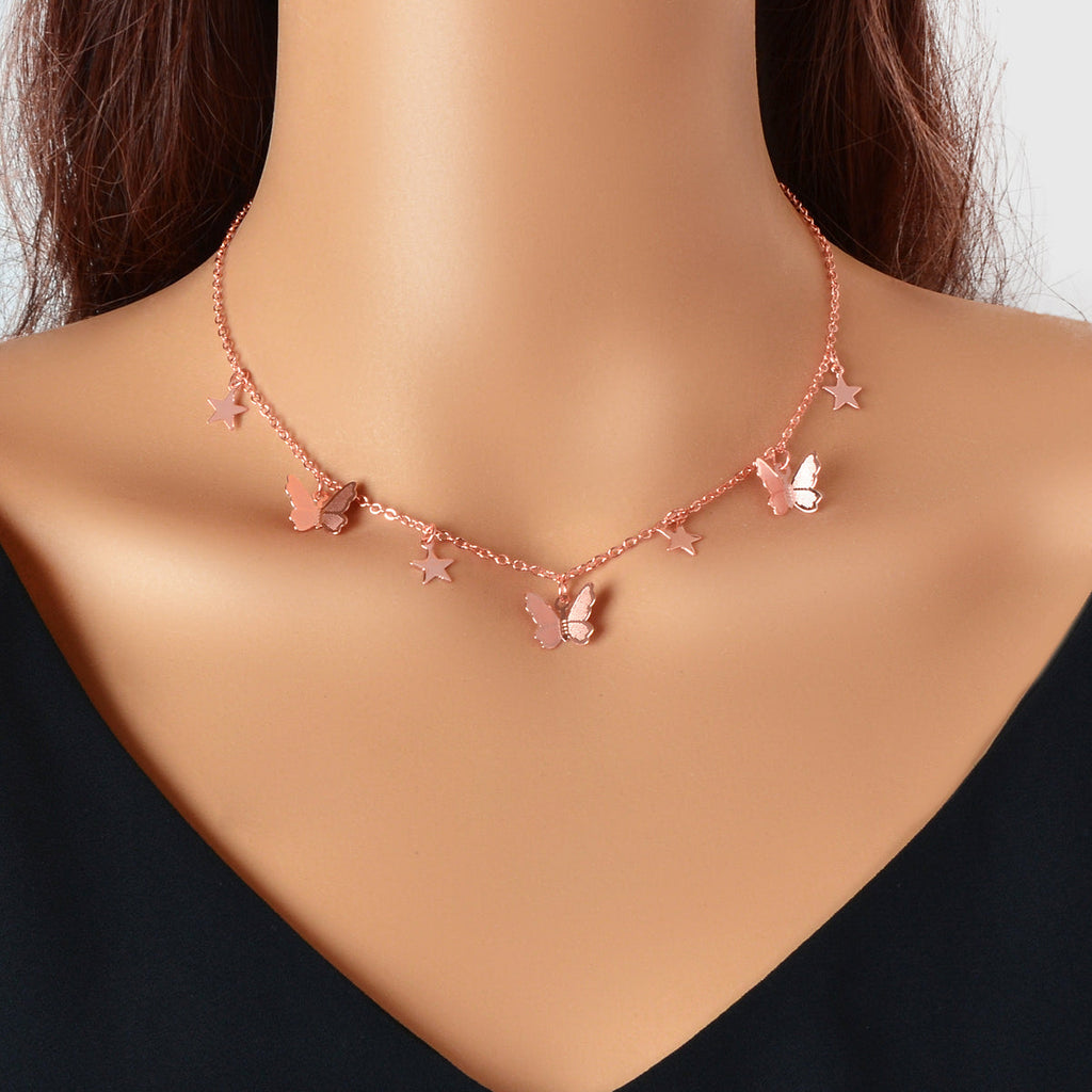 Rose-gold tone collar necklace with star and butterfly charms, short neckline fit