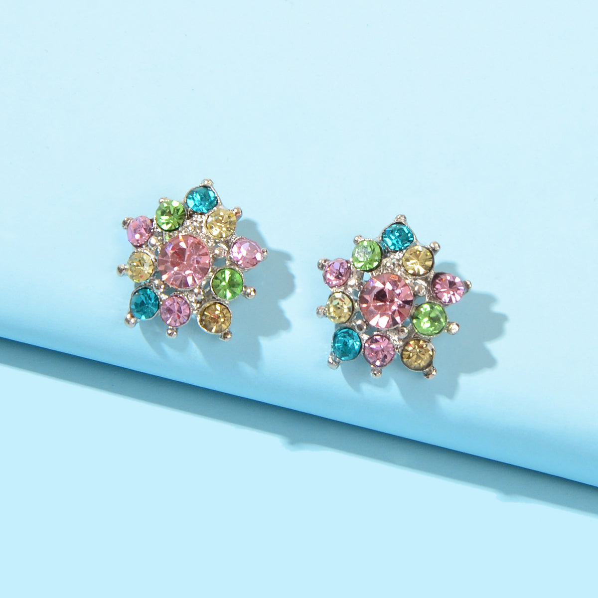 Pair of colorful rhinestone star ear studs with multicolor gemstone-like stones
