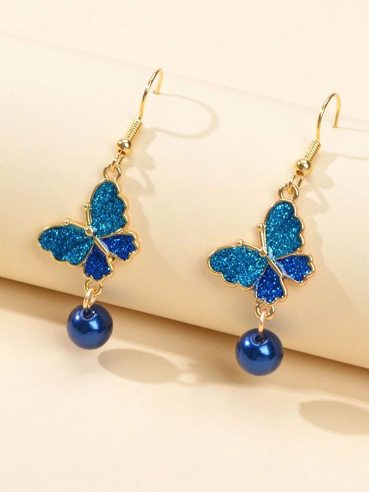 Blue glitter butterfly dangle earrings with dark blue bead drops