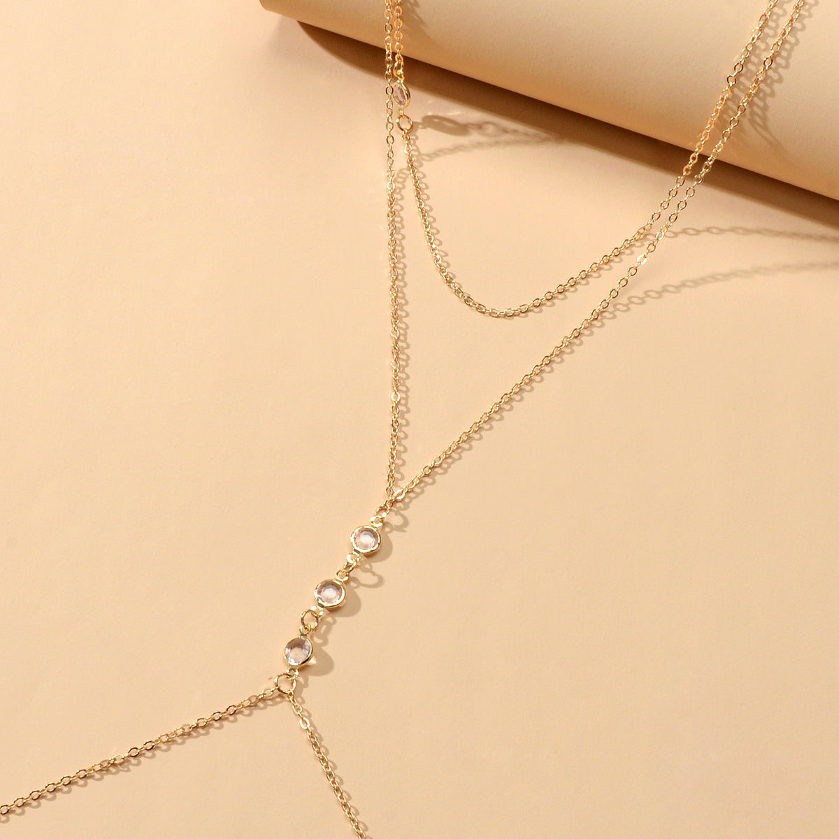 Gold-tone body chain with round charm links and delicate chain strands