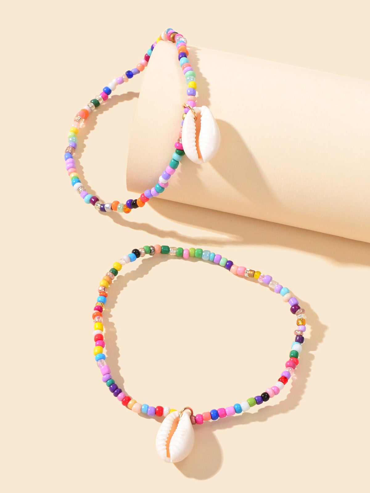 Set of two multicolor bead ankle bracelets with white cowrie shell charms