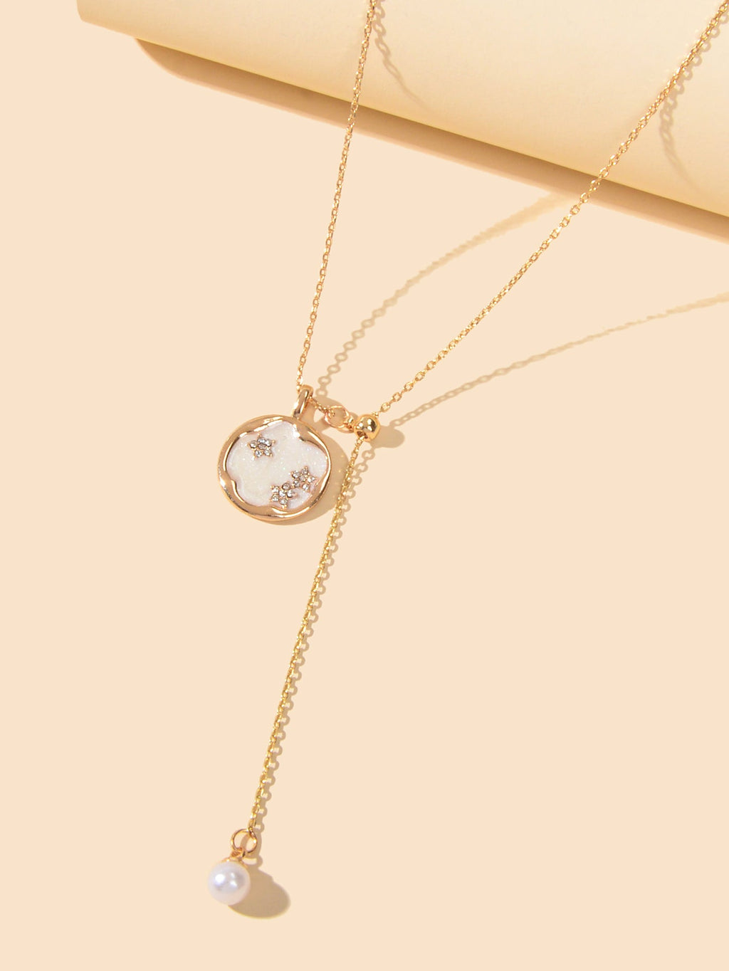 Gold-tone Y necklace with round pendant and small dangling pearl at end