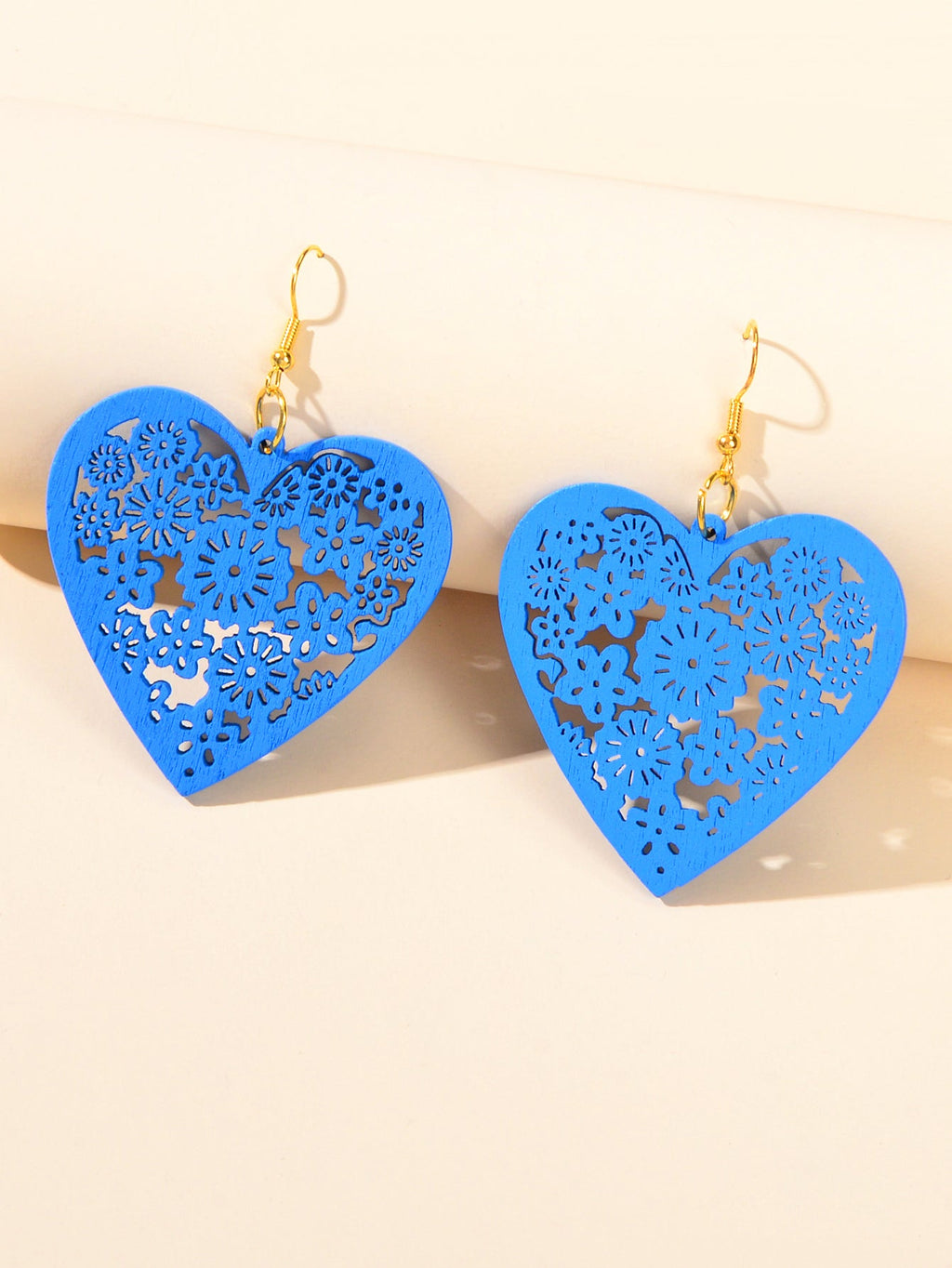 Blue heart dangle earrings with floral cutout pattern and gold hooks
