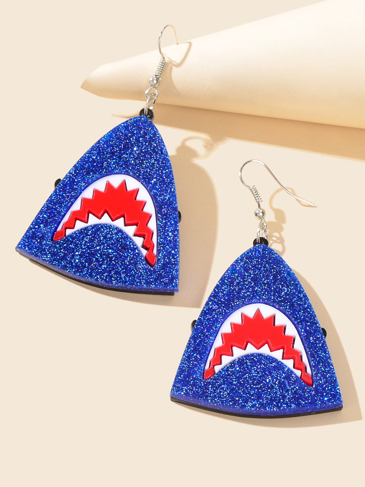 Blue glitter triangular shark-face earrings with red and white accents, pair