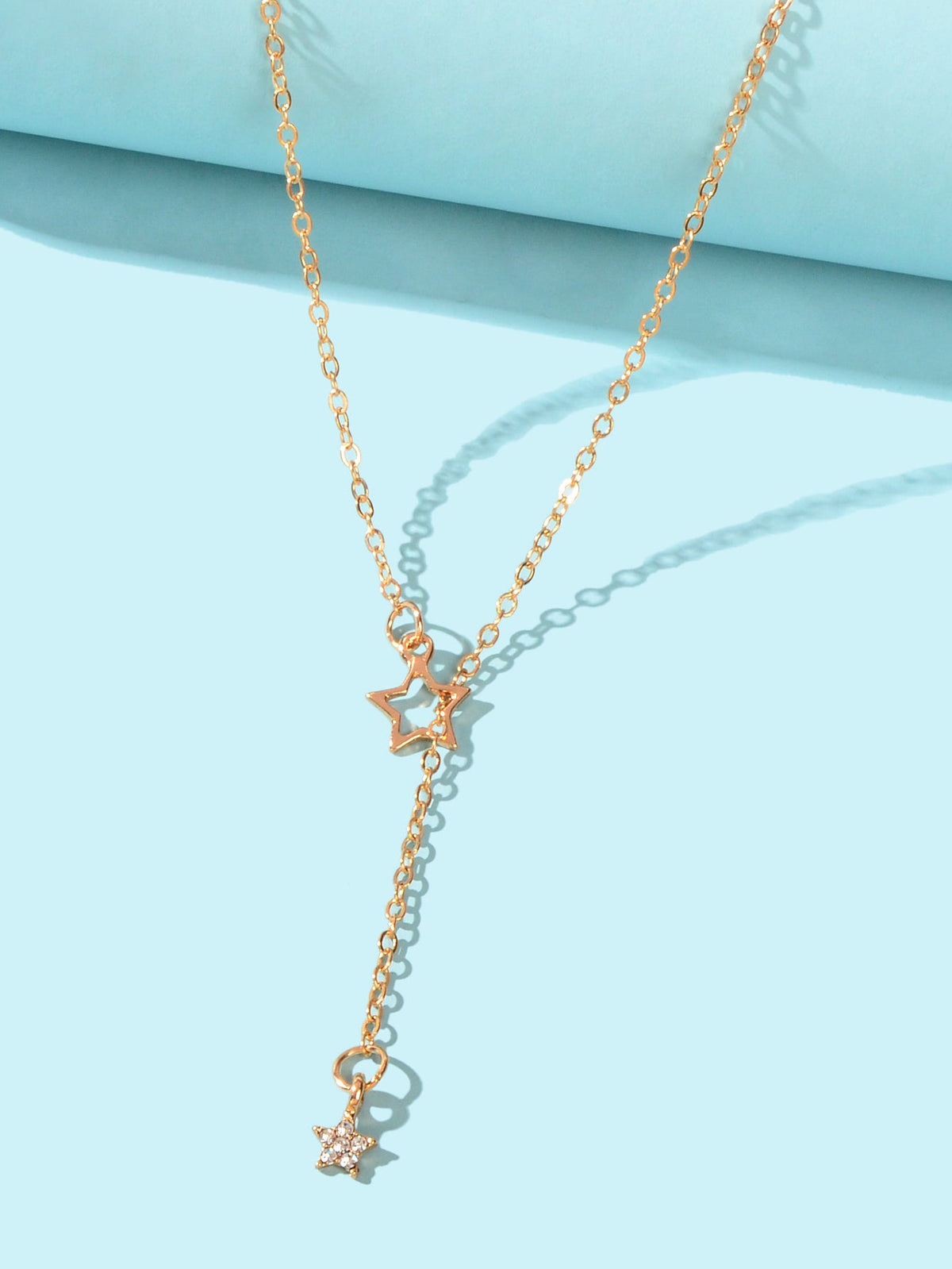 Gold lariat necklace with layered Y-chain and three star charm drops