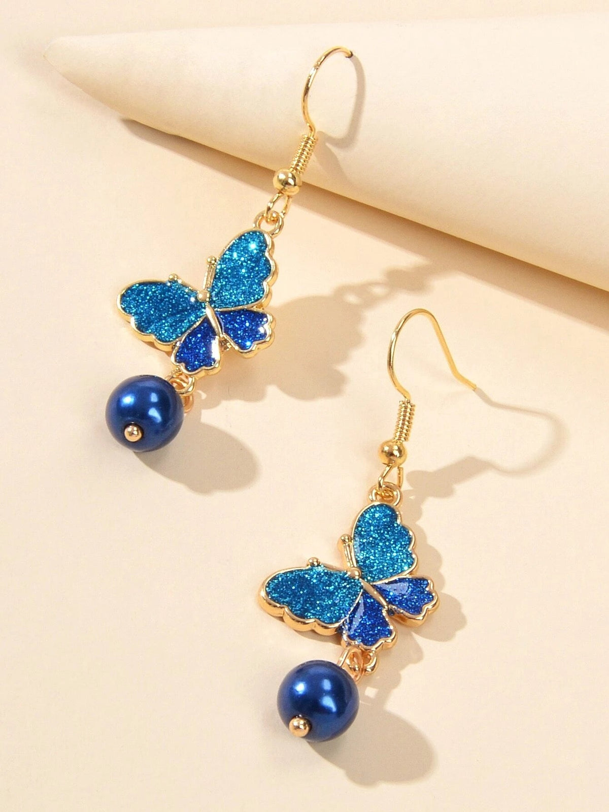 Blue butterfly dangle earrings with glitter wings and dark blue bead drops