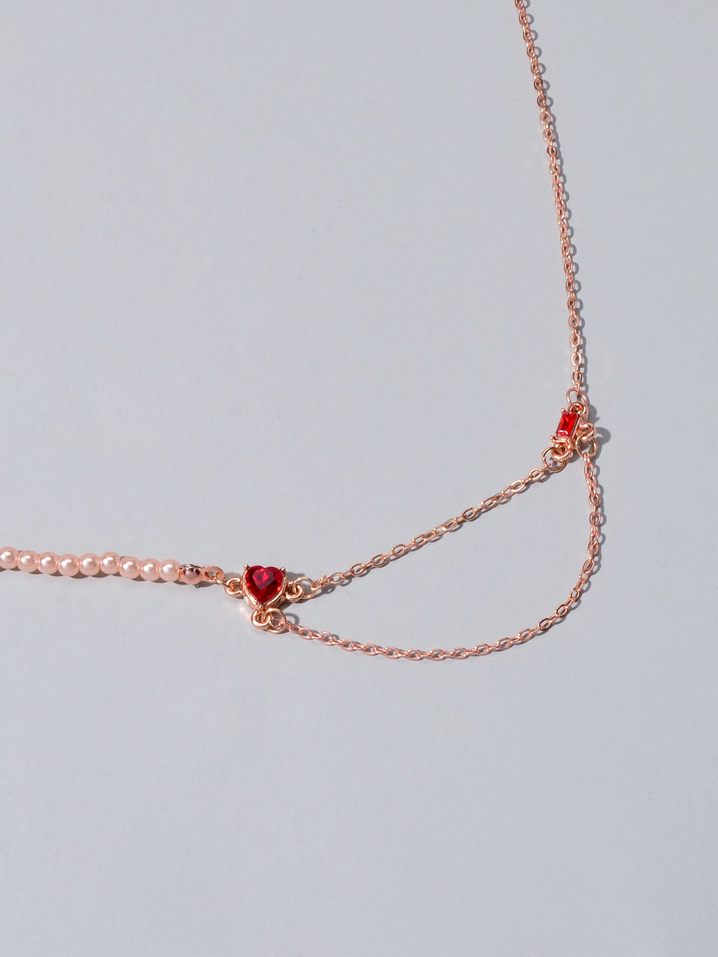 Rose gold tone chain necklace with red crystal heart-shaped centerpiece