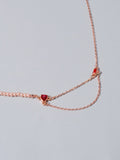 Rose gold tone chain necklace with red crystal heart-shaped centerpiece
