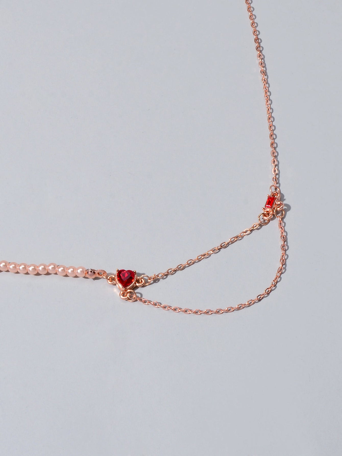 Rose gold tone chain necklace with red crystal heart-shaped centerpiece
