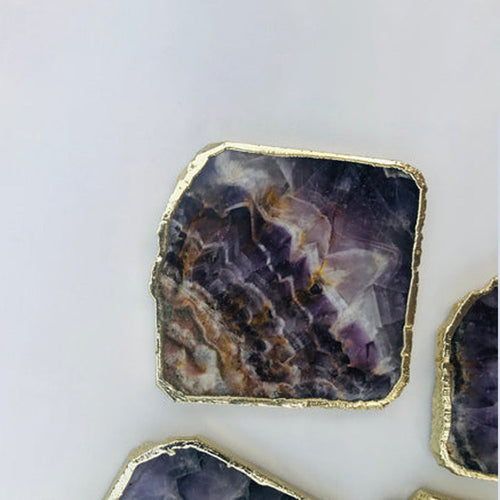 Amethyst slice coaster with gold-toned rim, purple-gray facets and natural edge