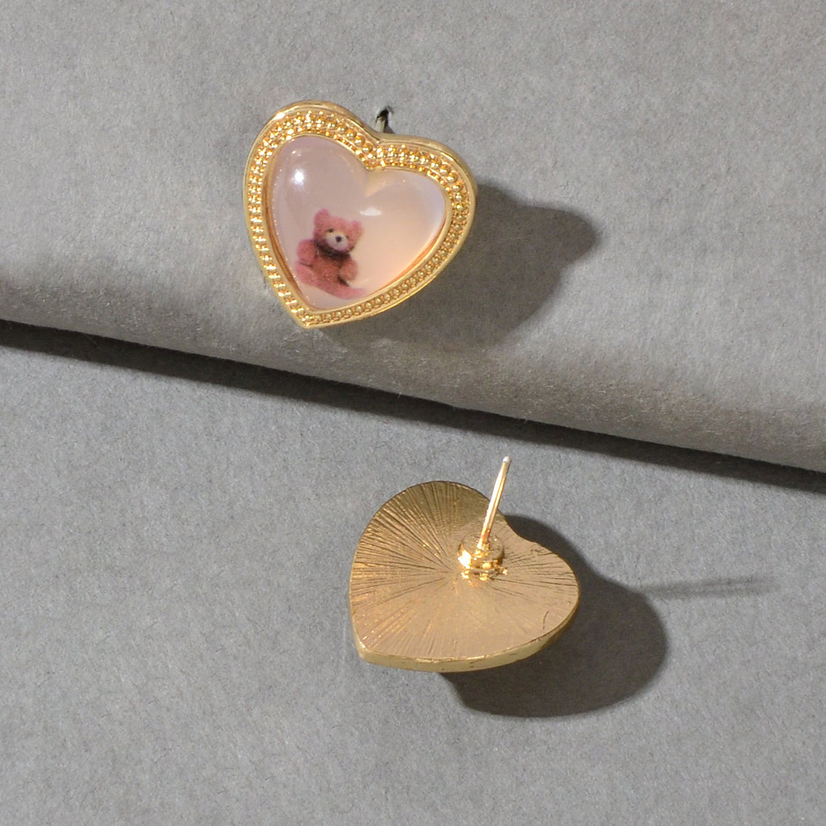 Gold heart resin stud earrings with pink bear scene inside