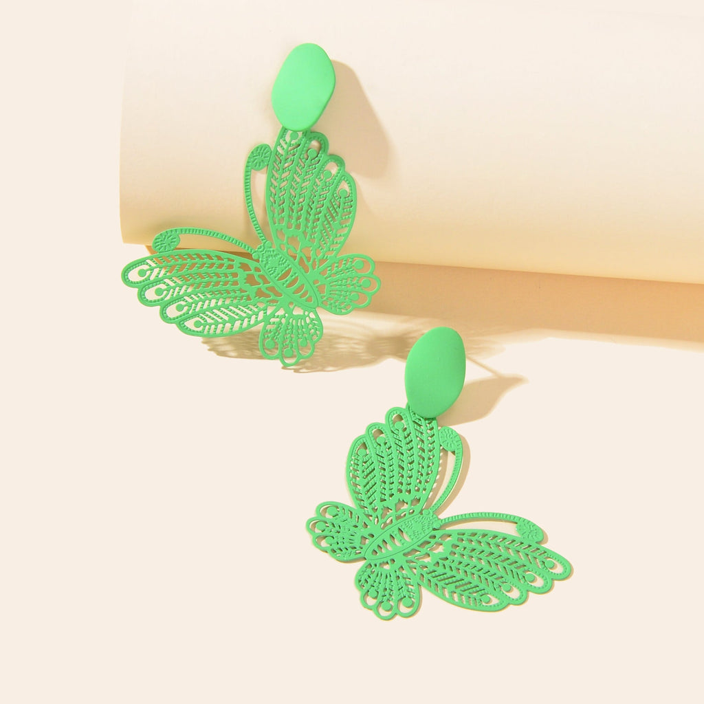 Green hollow butterfly stud earrings with large winged charm, angled view