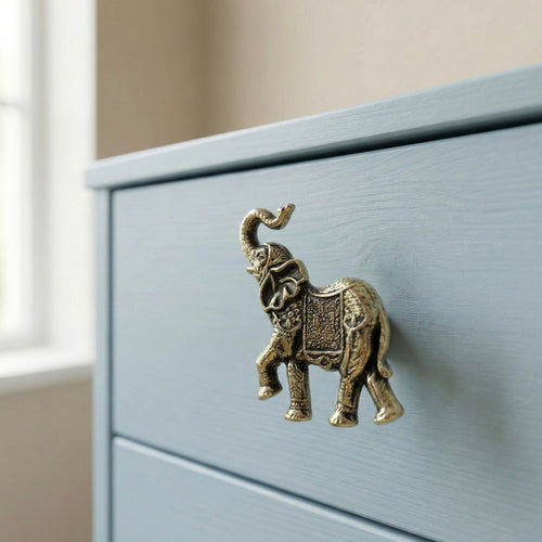 Close-up antique brass elephant drawer knob with ornate etched detailing