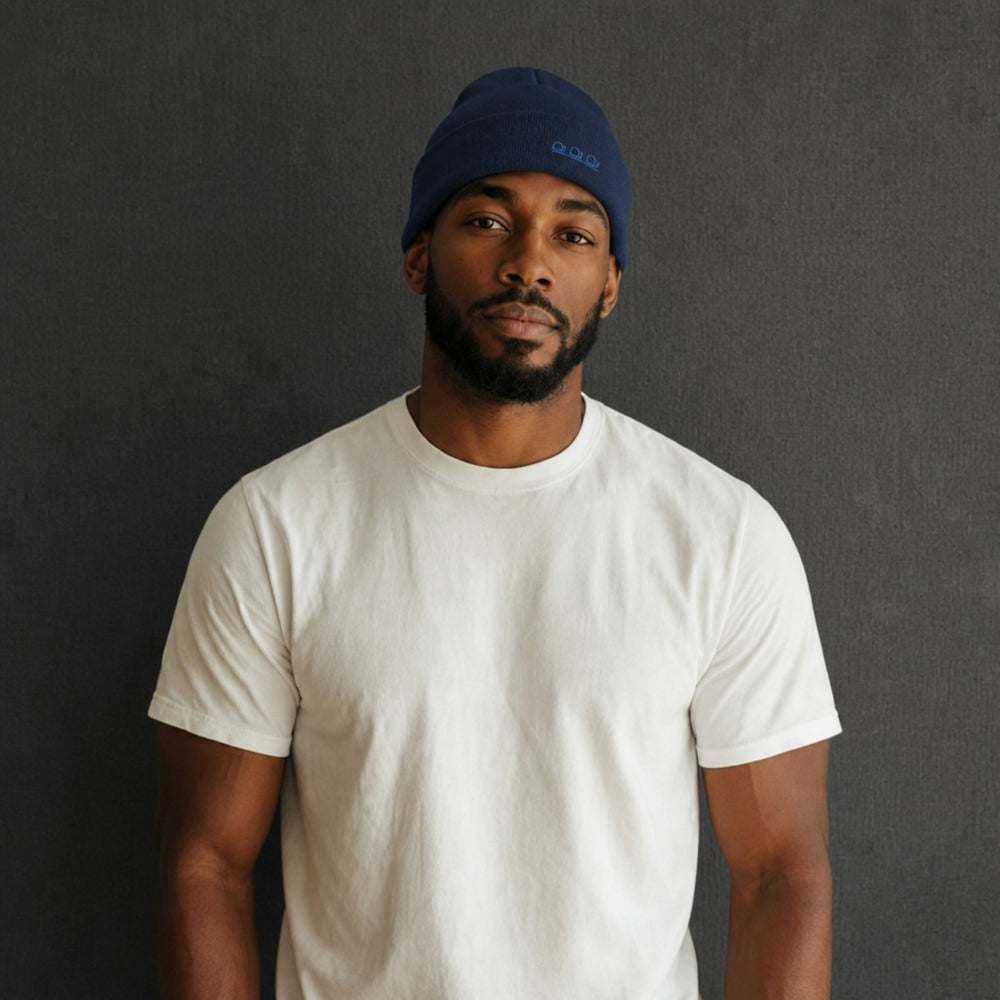 Blue knit beanie worn by model, ribbed cuff and small logo