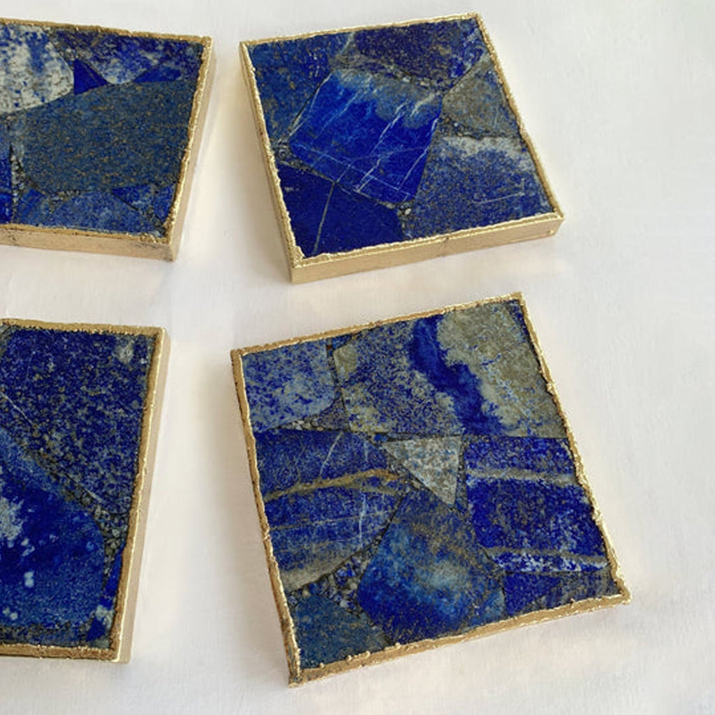 Four square lapis blue coasters, close top view with gold-toned borders