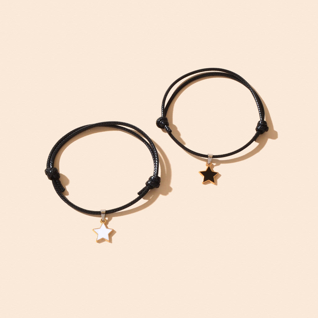 Pair of black adjustable rope bracelets with gold star charms, side by side