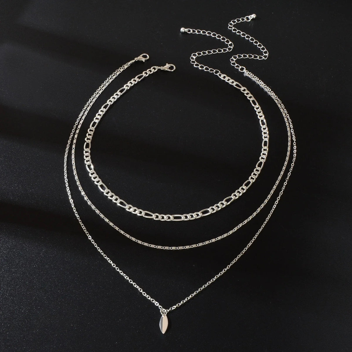 Layered silver-tone choker necklace with oval drop charm and three chain strands
